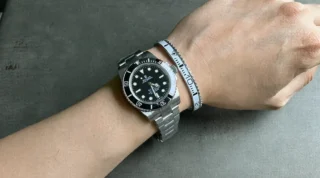 Close-up of Submariner Black Dial 124060 No-Date watch with clean white bezel on a man's wrist, premium titanium steel bracelet