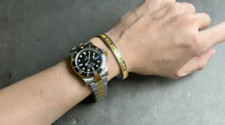 Close-up of Submariner Black Dial 126613LN watch with bright yellow bezel on a man's wrist, premium titanium steel bracelet